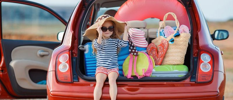 Hier sieht man ein vollbepacktes Auto auf dem Weg in den Urlaub