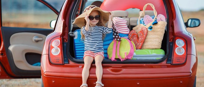 Hier sieht man ein vollbepacktes Auto auf dem Weg in den Urlaub